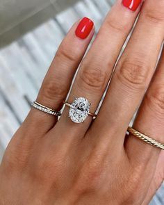 a woman's hand with three different rings on her fingers and one ring in the middle