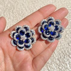 Sapphire Stud Earrings featuring semi precious navy blue stone with cz diamonds in a floral design. These PREMIUM QUALITY earrings can be apart from each others and you can wear these earrings in a multiple ways and create multiple looks. Perfect gift for her. *𝐏𝐑𝐎𝐃𝐔𝐂𝐓 𝐃𝐄𝐓𝐀𝐈𝐋* * 𝐌𝐚𝐭𝐞𝐫𝐢𝐚𝐥: Brass * 𝐏𝐥𝐚𝐭𝐢𝐧𝐠: White Rhodium Plated * 𝐒𝐭𝐨𝐧𝐞: AAA-quality CZ Diamond, Sapphire. *𝐃𝐈𝐌𝐄𝐍𝐒𝐈𝐎𝐍𝐒* * 𝐖𝐞𝐢𝐠𝐡𝐭: 8 gm each * 𝐋𝐞𝐧𝐠𝐭𝐡: 1.15 Inches * 𝐖𝐢𝐝𝐭𝐡:  1.15 Inches * 𝐂𝐥𝐨𝐬𝐮𝐫𝐞: Push Back 𝐕𝐢𝐬𝐢𝐭 𝐎𝐮𝐫 𝐅𝐀𝐐𝐬 𝐟𝐨𝐫 𝐒𝐡𝐢𝐩𝐩𝐢𝐧𝐠 𝐏𝐨𝐥𝐢𝐜𝐢𝐞𝐬 𝐚𝐧𝐝 𝐂𝐚𝐫𝐞 𝐈𝐧𝐬𝐭𝐫𝐮𝐜𝐭𝐢𝐨𝐧 *𝐃𝐈𝐒𝐂𝐋𝐀𝐈𝐌𝐄𝐑* * Product color may slightly vary due to photographic lighting sources or your screen settings. * Stone color may vary slightly due to Blue Sapphire Earrings Studs, Sapphire Earrings Studs, Deco Blue, Sapphire Studs, Earrings Art, Blue Sapphire Diamond, Bride Gift, Art Deco Earrings, Sapphire Earrings