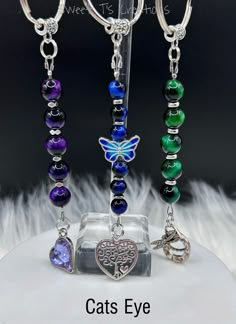 the cat's eye charm is attached to a keychain with beads and charms