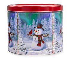 a christmas tin with a snowman and two birds on the tree branch in front of it