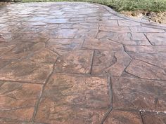 a stone patio with grass in the background