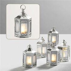 four white lanterns with lights inside them