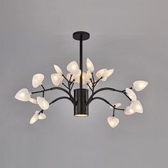 a black chandelier with white flowers hanging from it's center and four lights on each side