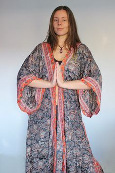 "*◅ ↠ ॐ ☽ ◅* Namaste *▻ ☾ ॐ  *◅ ☽ Anahata Kimono ☾ ▻* in Charcoal Rust Our silk kimonos are handcrafted & designed in India using Saree silks  Featuring long flared sleeves & detachable tie belt for extra shape.  Wear open and billowing or synch in at the waist. Perfect for any season! Cover up by the beach or add a pop of colour to your Winter wardrobe. The silk is surprisingly warm; holding in heat while simultaneously airy.  Team with skinny jeans or over some flares for an effortlessly Bohemian dream look. *PLEASE NOTE* Each and every one of our beautiful kimonos are made by hand. The same material is used for each piece, however, there may be small differences in the positioning of the print. This is an addition to the charm of each kimono, since they are all truly unique.  *◅ ↠ ॐ ☽ ◅ Fitted Bohemian Kimono For Festivals, Fitted V-neck Bohemian Kimono, Fitted Red Bohemian Kimono, Bohemian Orange Wrap Kimono, Orange Long Sleeve Kimono For Festivals, 70s Festival, Silk Wrap Top, Boho Robes, Beautiful Kimonos