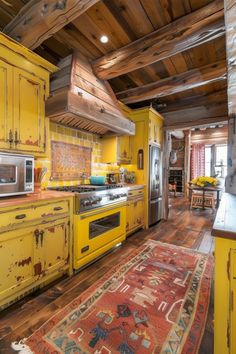 a kitchen with yellow painted cabinets and an area rug