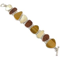 "What a stunning selection of stones this bracelet has! This is a vintage sterling silver bracelet that is created with glowing brown tiger eye, mother-of-pearl and deep red and black jasper stones! This is a designer piece by Whitney Kelly. The earthy shades make up a beautiful color selection. They are set into a sterling bezels. The pieces are nice and big. The silver is shiny. The bracelet conforms easily to your wrist so it is comfortable to wear. The clasp is a toggle. Beautiful piece to w Handmade Sterling Silver Brown Bracelet, Handmade Brown Sterling Silver Bracelets, Brown Gemstone Bracelet, Black Jasper, Brown Tiger, Brown Tiger Eye, Pearl Vintage, Vintage Bracelet, Bracelet Sterling Silver