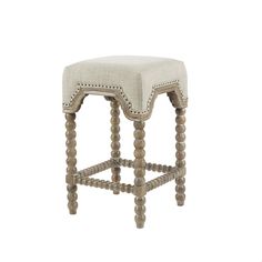 an upholstered stool with wooden legs and beaded trimmings on the seat