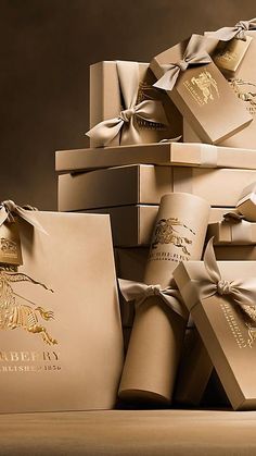 a pile of brown boxes with gold foil designs on them and ribbons tied around them