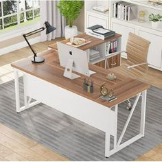 a computer desk with a laptop on it in front of a bookcase and bookshelf