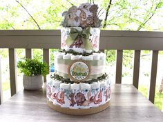 a three tiered diaper cake sitting on top of a wooden table