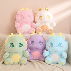 three stuffed animals sitting on top of a bed next to each other in different colors