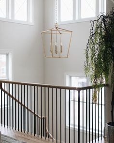 a chandelier hanging from the ceiling in a living room next to a stair case