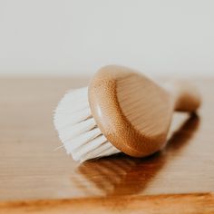 a wooden brush sitting on top of a wooden table