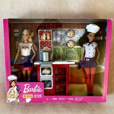 two barbie dolls are standing in the kitchen