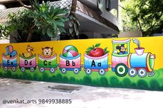 a mural on the side of a building depicting a train with children's pictures