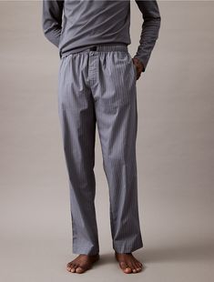 Crafted from 100% cotton, these pants are breathable with a lightweight feel. Cut with a mid rise waist and detailed with slip pockets at the sides. Finished with a Calvin Klein logo tag at the center waist.  Material: 100% Cotton. Calvin Klein Cotton Boxer Briefs For Loungewear, Calvin Klein White Loungewear Bottoms, Calvin Klein Cotton Straight Leg Pants, Calvin Klein Men's Bottoms With Logo Waistband, Mens Pj Poplin Pants, Sleep Pants, Mens Fashion Casual Outfits, Classic Shoes, Lounge Pants