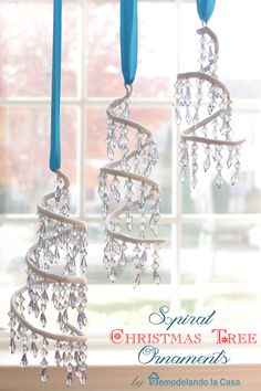 three chandeliers hanging in front of a window with blue ribbons and crystal beads