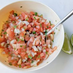 a white bowl filled with chopped up vegetables and garnished with cilantro