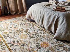 a bedroom with a large rug on the floor and a bed in front of it