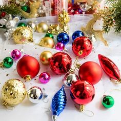 many different colored christmas ornaments on a table