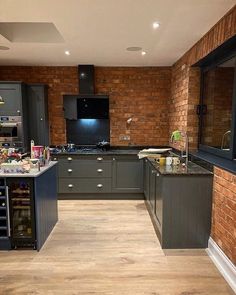 a kitchen with brick walls and wooden floors