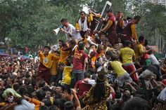 a group of people standing on top of each other in the middle of a crowd