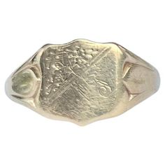 The main detail on this ring is the shield with corner engraving. The chunky shoulders are smooth and carry on down into a plain band modelled in 9ct gold. Made in Birmingham 1964, England. RIng Size: S or 9 Widest Part: 12mm Weight: 3.4g Classic 14k Stamped Signet Ring For Commemoration, Classic Oval Signet Ring With Coat Of Arms, Classic Collectible Signet Ring With Engraving, Antique Gold Signet Ring For Commemoration, Classic Hallmarked Signet Ring For Commemoration, Gold Antique Signet Ring For Commemoration, Classic Signet Ring With Coat Of Arms For Anniversary, Classic Hallmarked Engraved Ring For Commemoration, Classic Engraved Signet Ring For Commemoration