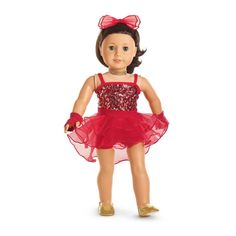 a doll wearing a red dress and gold shoes with a pink bow on her head