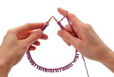 two hands are holding yarn and knitting needles