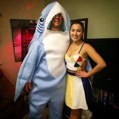 a man and woman dressed up as shark and girl in costume standing next to each other