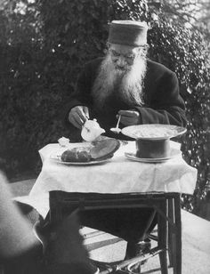 an old man sitting at a table eating food