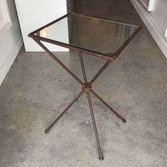 a glass table sitting on top of a cement floor