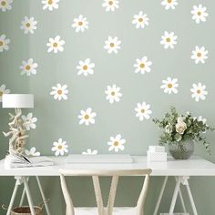 a white desk sitting under a wall with flowers on it