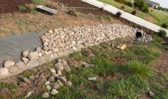 there is a rock wall built into the side of this yard to protect it from falling rocks