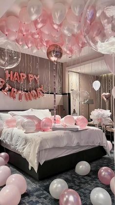 a bedroom decorated with balloons and streamers for a happy birthday party in pink, white and silver