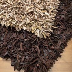 a pile of brown and white rugs sitting on top of a wooden floor