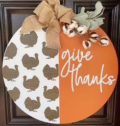 a door hanger that says give thanks and is decorated with an orange circle, brown duck