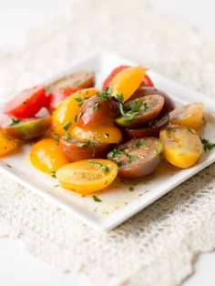 a white plate topped with sliced tomatoes and cucumbers