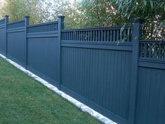 a blue fence in the grass next to a tree