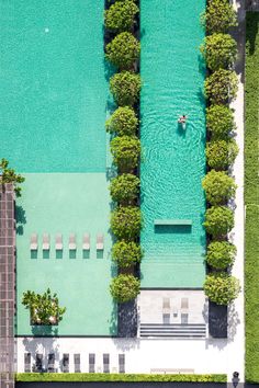 an aerial view of a man in a kayak on the water next to some trees