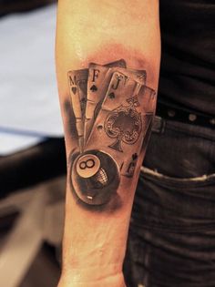 a man with a tattoo on his arm holding a pool ball and billiards