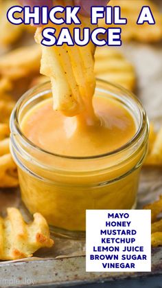 a spoon dipping sauce into a jar filled with fries