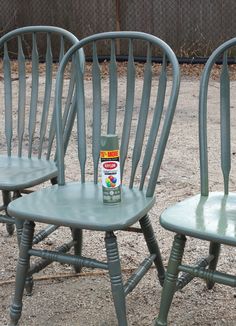 two green chairs sitting next to each other with a can of paint on the back