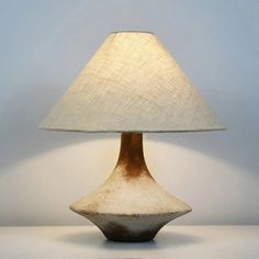 a table lamp sitting on top of a white counter next to a blue and white wall