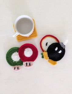 two crocheted coasters and a coffee cup on a white surface with a mug in the middle