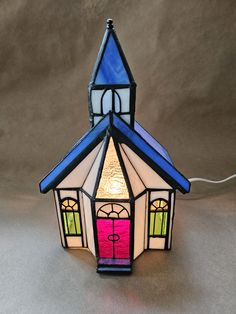 a small stained glass church with a pink door