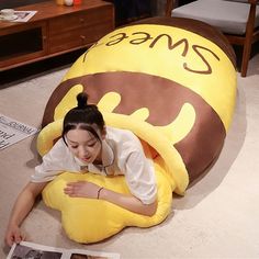 a woman laying on the floor next to a giant stuffed animal