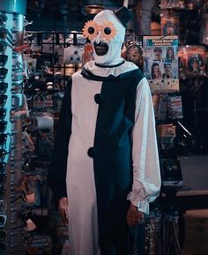 a person wearing a costume and mask in a room with many items on the wall