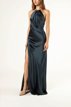 Pure silk charmeuse halter gown with front pleat draping. Features an open back detail and a front slit. Invisible center back zipper closure and fully lined in silk. Made in USA. Composition: 100% silk Pleat Draping, Draped Gown, Black Tie Wedding Guests, Drape Gowns, Black Bridesmaids, Michelle Mason, Bias Cut Skirt, Halter Gown, Black Tie Dress