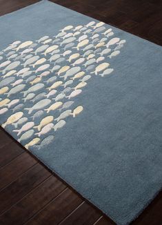 a rug with fish on it in the middle of a wooden flooring area,